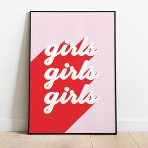 May include: A framed print with a pink and red background. The text "girls girls girls" is written in white on the red background.