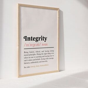 May include: A framed print with a white background and black text defining the word "Integrity". The definition is: "Being honest, ethical, and having strong moral principles. Doing the right thing even when no one is watching and staying true to one's values and beliefs. Acting with courage, fairness, authenticity and sincerity. See also: honesty, honour, trustworthiness"