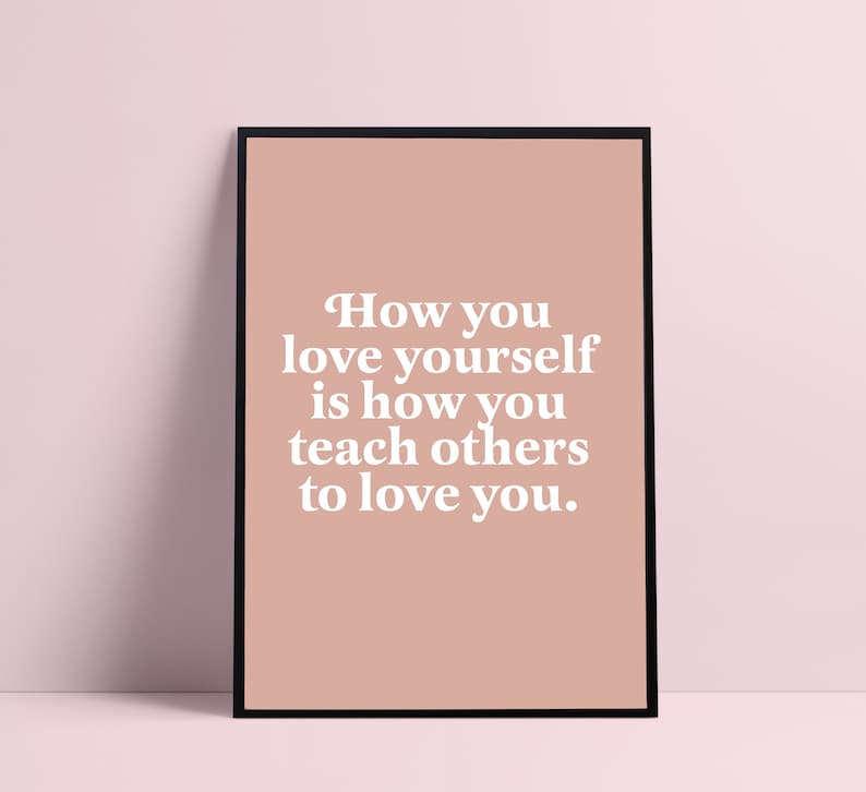 Op de afbeelding: Een printbare wandposter met een roze achtergrond en witte tekst die luidt: "Hoe je van jezelf houdt, is hoe je anderen leert van je te houden."