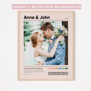 May include: A blush pink background with a wedding poster design. The poster features a photo of a couple kissing, with the text "Anne & John" and "2022" above the photo. The poster also includes the text "Starring: Anne Smith & John Henderson" and a PG-13 rating.