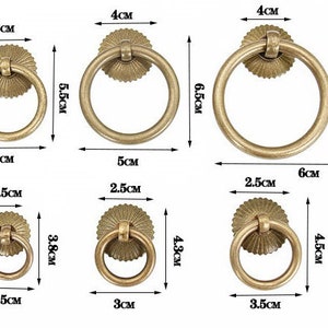 May include: Set of ten antique brass ring pulls in various sizes. The pulls have a decorative, fluted design around the ring. The largest pull measures 6 cm in diameter and the smallest measures 2.5 cm in diameter.