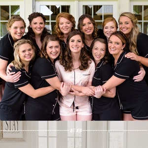 May include: A group of women wearing black and white pajamas with white trim. The women are smiling and posing for a photo. The text "SLAY" is visible in the background.
