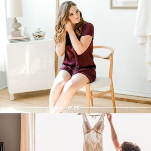May include: Two people in matching burgundy pajamas getting ready for a wedding. One person is sitting on a chair and putting on earrings. The other person is holding up a white lace wedding dress.