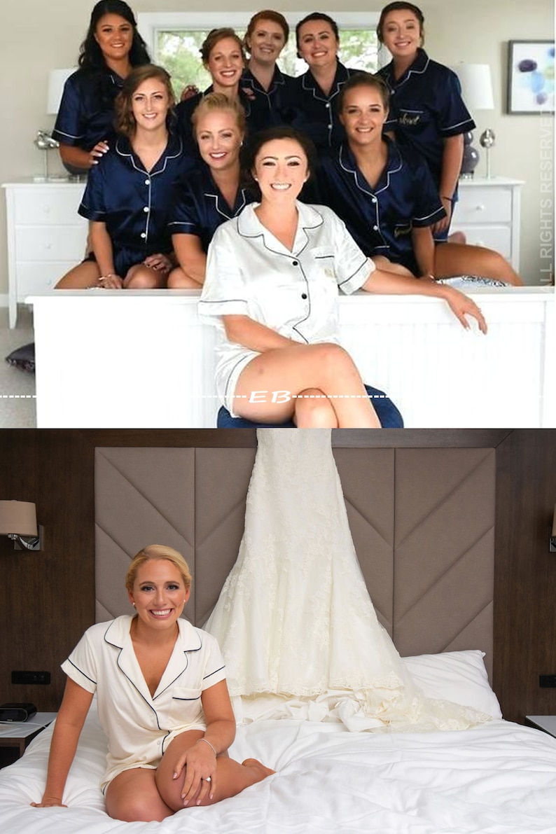 May include: A group of bridesmaids in matching navy blue pajamas with white trim and the word "Bride" embroidered on the front. The bride is wearing a white satin pajama set with black trim. The bridesmaids are sitting on a white bed, and the bride is standing in front of them.