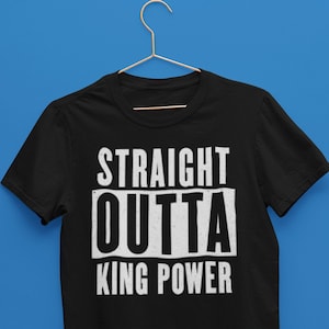 Puede incluir: Camiseta negra con texto blanco que dice "STRAIGHT OUTTA KING POWER".