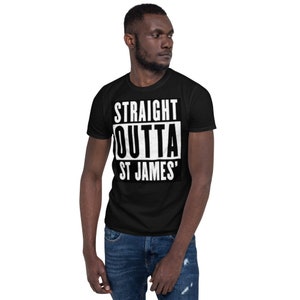 May include: Black t-shirt with the white text "STRAIGHT OUTTA ST JAMES'" in a bold, blocky font. The shirt is a classic crew neck style and is worn by a person in blue jeans.