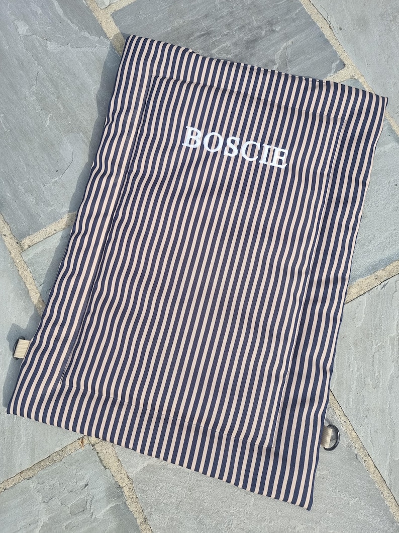 Cotton dog settle mat with shoulder strap and popper fastening. The mat for dogs helps with training a dog or puppy to settle. It makes a perfect gift for dogs and tool for puppy training. The puppy settle training pad is available is different colours and made easy to carry.