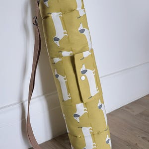 Cotton dog settle mat with shoulder strap and popper fastening. The mat for dogs helps with training a dog or puppy to settle. It makes a perfect gift for dogs and tool for puppy training. The puppy settle training pad is available is different colours and made easy to carry.