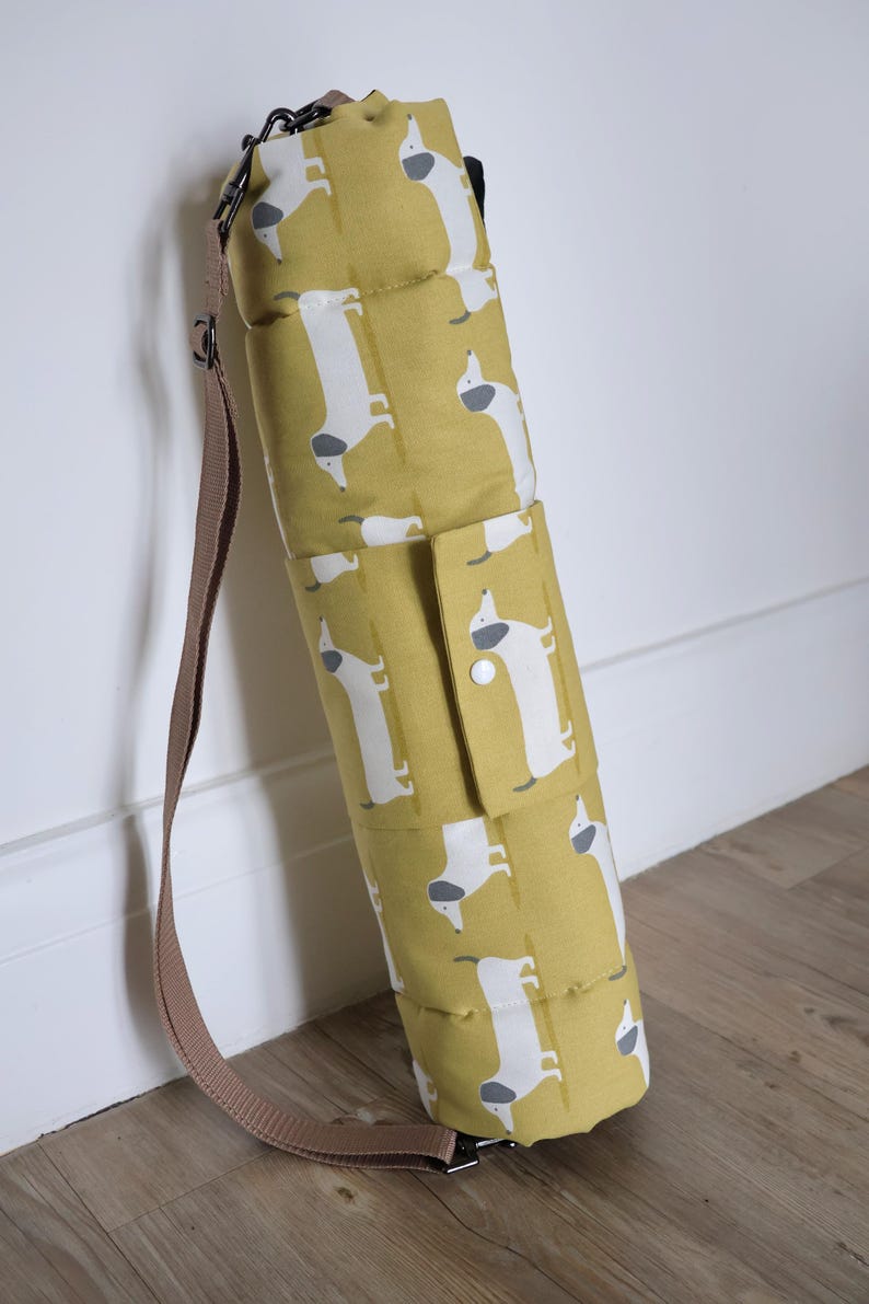 Cotton dog settle mat with shoulder strap and popper fastening. The mat for dogs helps with training a dog or puppy to settle. It makes a perfect gift for dogs and tool for puppy training. The puppy settle training pad is available is different colours and made easy to carry.