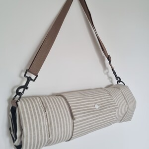 Cotton dog settle mat with shoulder strap and popper fastening. The mat for dogs helps with training a dog or puppy to settle. It makes a perfect gift for dogs and tool for puppy training. The puppy settle training pad is available is different colours and made easy to carry.
