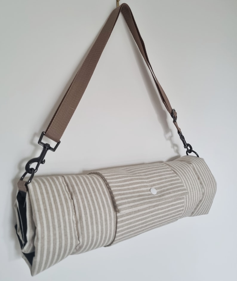 Cotton dog settle mat with shoulder strap and popper fastening. The mat for dogs helps with training a dog or puppy to settle. It makes a perfect gift for dogs and tool for puppy training. The puppy settle training pad is available is different colours and made easy to carry.