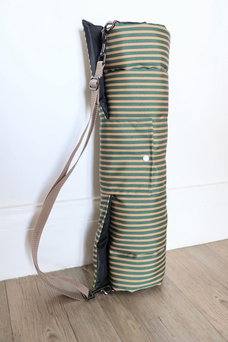 Cotton dog settle mat with shoulder strap and popper fastening. The mat for dogs helps with training a dog or puppy to settle. It makes a perfect gift for dogs and tool for puppy training. The puppy settle training pad is available is different colours and made easy to carry.
