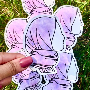 May include: Five purple and white watercolour stickers of a woman's profile wearing a headscarf. The stickers are outlined in black.
