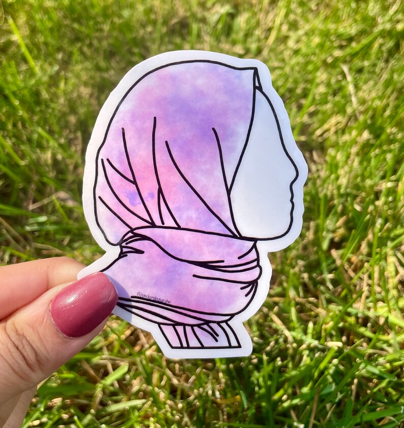May include: A purple and pink watercolour sticker of a person wearing a headscarf. The sticker is outlined in black.