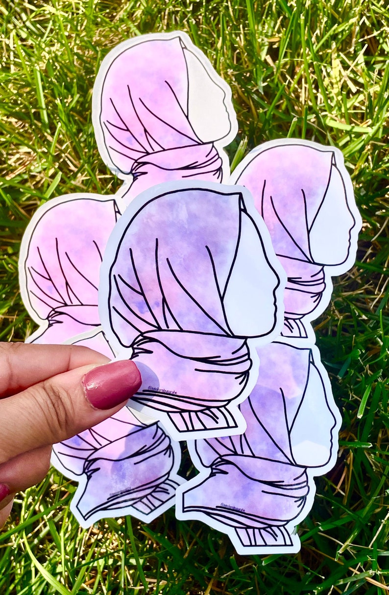 May include: Five purple and white watercolour stickers of a woman's profile wearing a headscarf. The stickers are outlined in black.