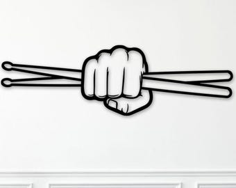 May include: Black and white wall art featuring a clenched fist holding two drumsticks. The artwork is a minimalist design, perfect for a music room or a drummer's space. The drumsticks are parallel and extend to the left.