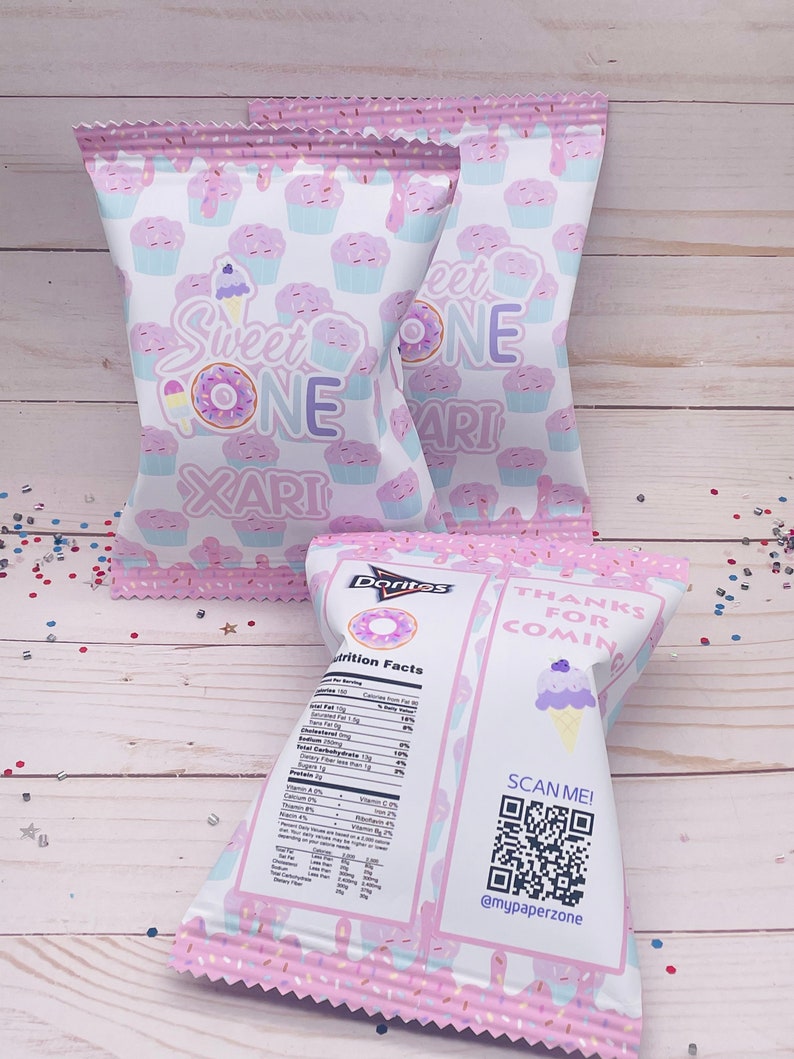May include: Pink and white favor bags with a donut and ice cream cone design. The bags have the text "Sweet One" and "Thanks for Coming". A QR code is printed on the bag with the text "Scan Me! @mypaperzone".