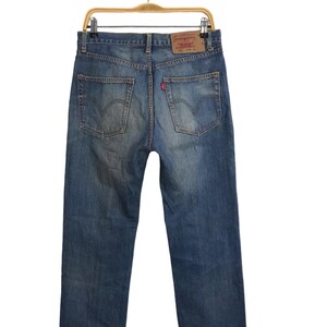 May include: A pair of blue denim jeans with a brown leather patch on the back pocket that says "Levi's" in white text.