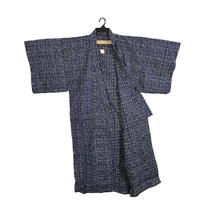 May include: A blue and white patterned kimono hangs on a black hanger. The kimono features a geometric design and is made of a lightweight fabric. The sleeves are wide and the garment is open at the front. A traditional Japanese garment.