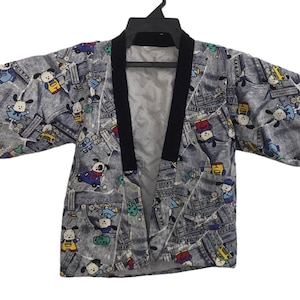 May include: A gray denim-look jacket featuring an all-over print of cartoon dog characters in various outfits. The jacket has wide sleeves, a black collar trim, and an open front design. The fabric pattern includes small blue, yellow, and red accents.