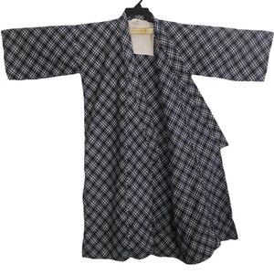 May include: A black and white plaid kimono-style robe hanging on a black hanger. The robe has wide sleeves and a wrap-around design. The plaid pattern is a classic design.