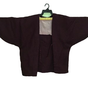 May include: A dark purple kimono with long sleeves and a tie closure at the front.