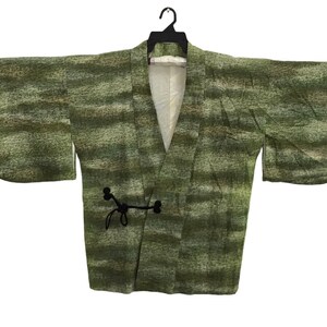 May include: A green and brown patterned kimono with black ties. The kimono is made of a soft, textured fabric.
