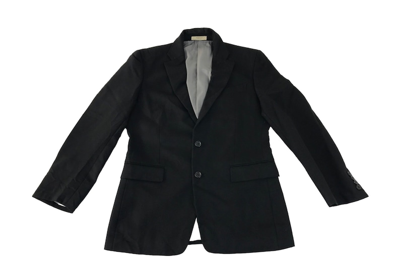 Puede incluir: Un blazer negro con cierre de dos botones, dos bolsillos delanteros y solapa con muescas. El forro interior es de color gris claro. Las mangas tienen botones en los pu&ntilde;os. El blazer se muestra sobre un fondo blanco.
