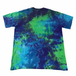 Puede incluir: Una camiseta tie-dye en tonos azules y verdes. La camiseta tiene un patr&oacute;n de color en espiral.