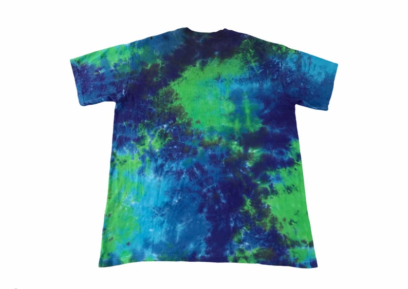 Puede incluir: Una camiseta tie-dye en tonos azules y verdes. La camiseta tiene un patr&oacute;n de color en espiral.