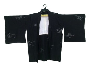 May include: A black Japanese kimono with a white cloud pattern. The kimono is open and hanging on a hanger.