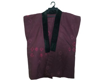 May include: A maroon Japanese haori jacket with a black velvet collar, hanging on a black hanger. The jacket features a diamond pattern in a darker shade of maroon. The haori is a traditional Japanese garment.