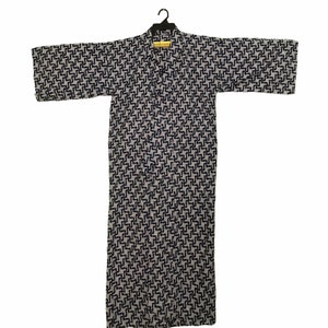 May include: A grey and navy blue patterned kimono robe hanging on a black hanger. The robe has a repeating geometric design. The robe is made of a lightweight fabric and has wide sleeves.