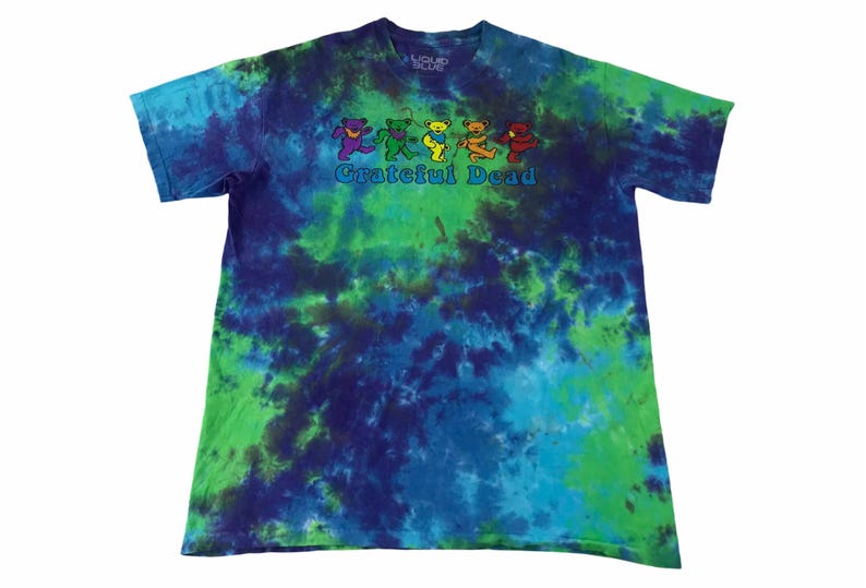 Puede incluir: Una camiseta tie-dye con un esquema de color verde, azul y morado. La camiseta presenta un gr&aacute;fico de cinco osos bailando con el texto "Grateful Dead" debajo.