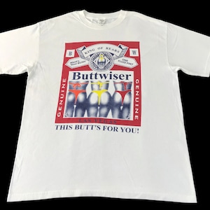 May include: White t-shirt with a graphic that parodies the Budweiser logo, featuring the word "Buttwise" and images of three posteriors in colorful thongs. The text "This Butt's For You!" is also included.