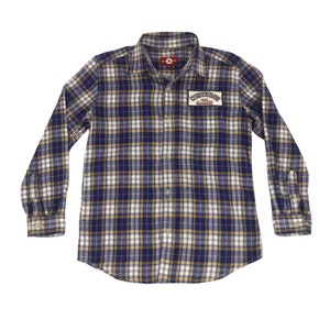 Puede incluir: Camisa de manga larga a cuadros en azul marino, blanco y beige. Presenta una botonadura, cuello y un parche en el pecho con "CONVERSE ALL STARS". Fabricada en tejido suave y tejido.