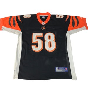 May include: Black and orange football jersey with the number 58 in white. The jersey has orange and black stripes on the sleeves and the number 58 on the front and back. The jersey has a v-neck collar.