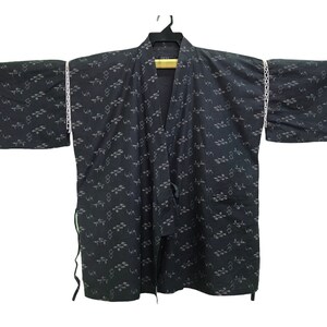 May include: A black kimono with a white geometric pattern. The kimono has long sleeves and a tie closure.