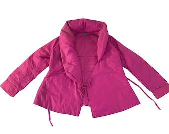 Könnte beinhalten: Magentafarbene Steppjacke mit breitem Schalkragen. Die Jacke hat lange Ärmel und einen Bindverschluss in der Taille. Hergestellt aus einem glatten Material, möglicherweise Nylon.