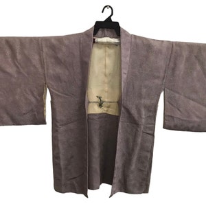 May include: A brown Japanese kimono with a cream-coloured lining. The kimono is open at the front and has a rope tie at the waist.