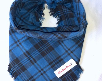 Peut inclure: Bandana pour chien à carreaux bleus et noirs avec des bords effilochés. Le bandana est noué en haut et comporte une petite étiquette blanche avec le texte "Maritime Paws" et une empreinte de patte.