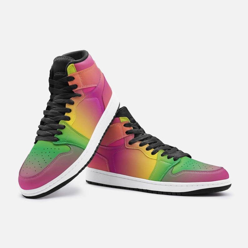 May include: High-top sneakers with a vibrant gradient design, transitioning from pink to green and yellow. The shoes feature black laces and a black collar, set against a white sole. A colorful and stylish footwear option.