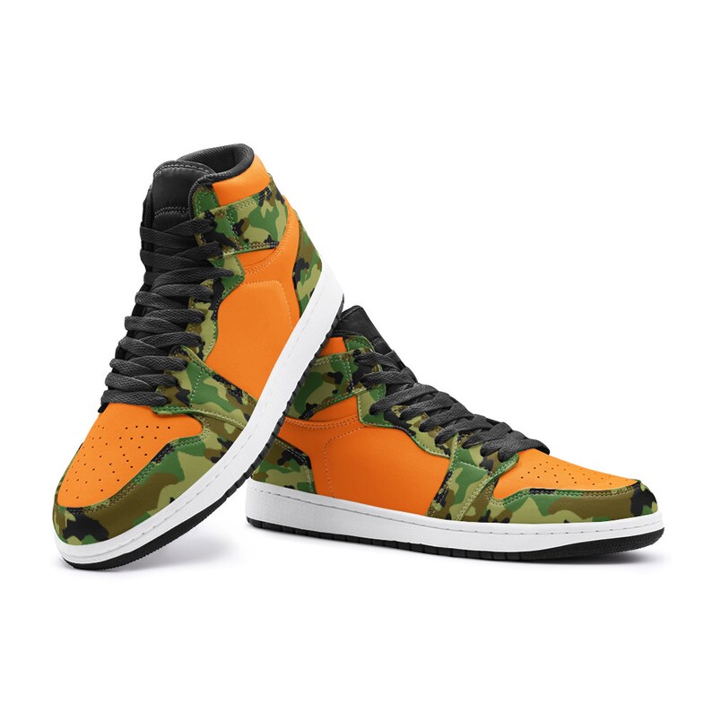 May include: High-top sneakers in a vibrant orange and camouflage pattern. The shoes feature black laces, a white sole, and a black collar. These sneakers are a stylish blend of bold color and classic design.