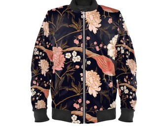 May include: A black bomber jacket with a floral pattern featuring pink peonies, white blossoms, and coral-colored birds. The jacket has a black collar, cuffs, and hem. The design is set against a dark background.