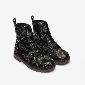 Puede incluir: Botas de combate negras con un dise&ntilde;o de drag&oacute;n y nubes doradas. Las botas tienen cordones negros, una leng&uuml;eta y una suela marr&oacute;n. El dise&ntilde;o est&aacute; inspirado en el arte asi&aacute;tico.