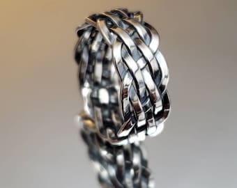 May include: A silver braided ring with a woven design.