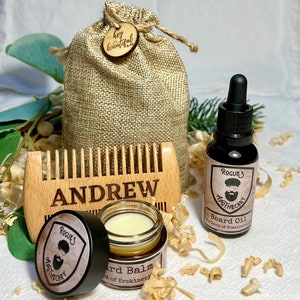 K&ouml;nnte beinhalten: Ein personalisierter Holzkamm mit dem eingravierten Namen "ANDREW", ein kleines Glas mit Bartbalsam, eine Flasche Bart&ouml;l und ein Jutesack mit einem Holzschild, auf dem "hey beautiful" steht.