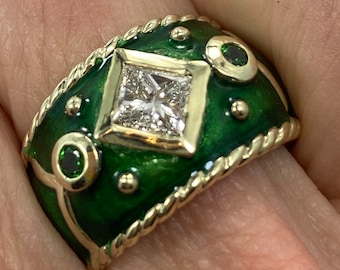 May include: A gold ring with a green enamel band and a square-shaped diamond in the center. The band is decorated with small gold balls and green gemstones.