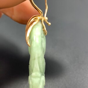 May include: A pair of green jade earrings with gold leaf accents and a gold hook closure.