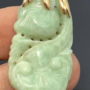 May include: A green jade pendant carved with a floral design, set in a gold bail.